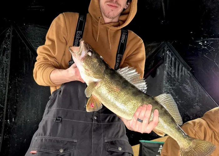 Man holding a fish ice fishing