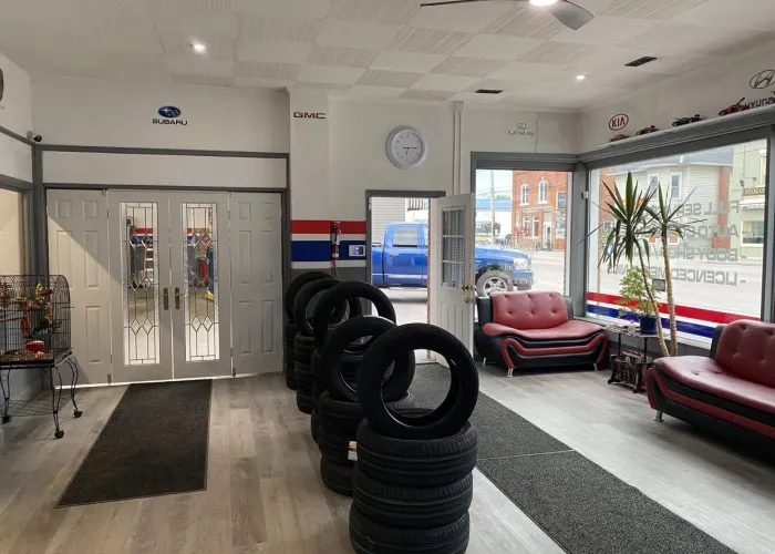 Room with white walls, large windows, red couches, tires in centre