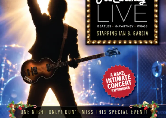 Silhouette of guitarist on stage holding guitar with fist in the air, drum set in background, name of show framed in lights top right, event details on bottom