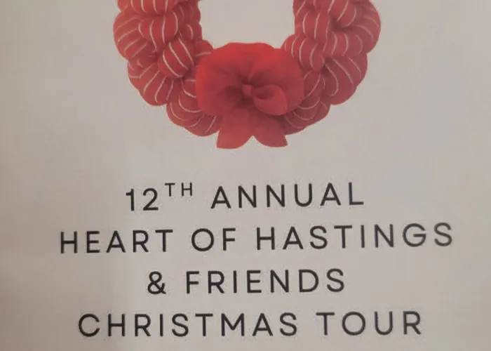 White background, red ribbon wreath in centre, name of event and event details in text above and below wreath