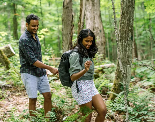 Couple hiking in a lush green forested trail in Madoc, Ontario