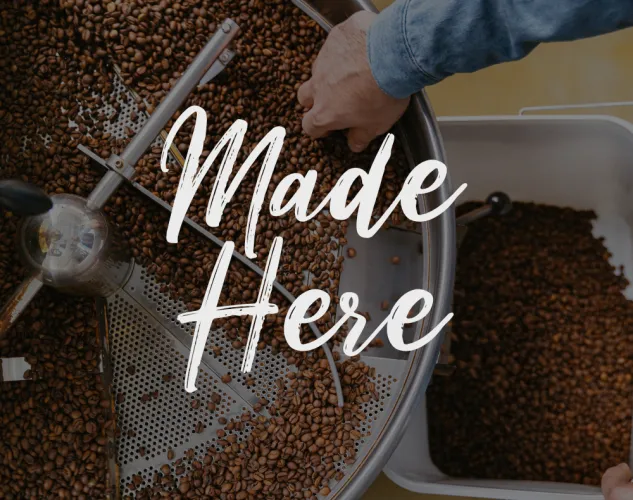 Made Here Title Photo, a person is roasting coffee in a large metal machine
